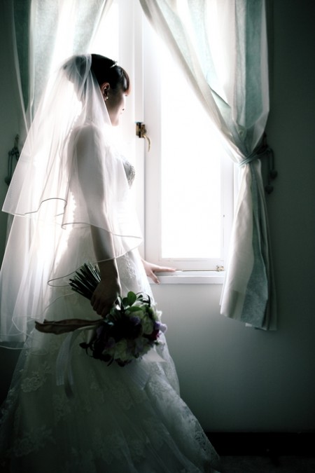 窓から景色を眺める花嫁
